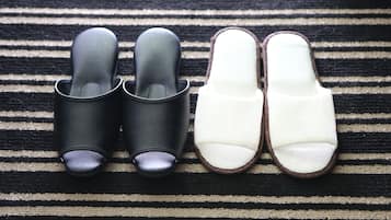 A pair of black and white slippers on a striped fabric.