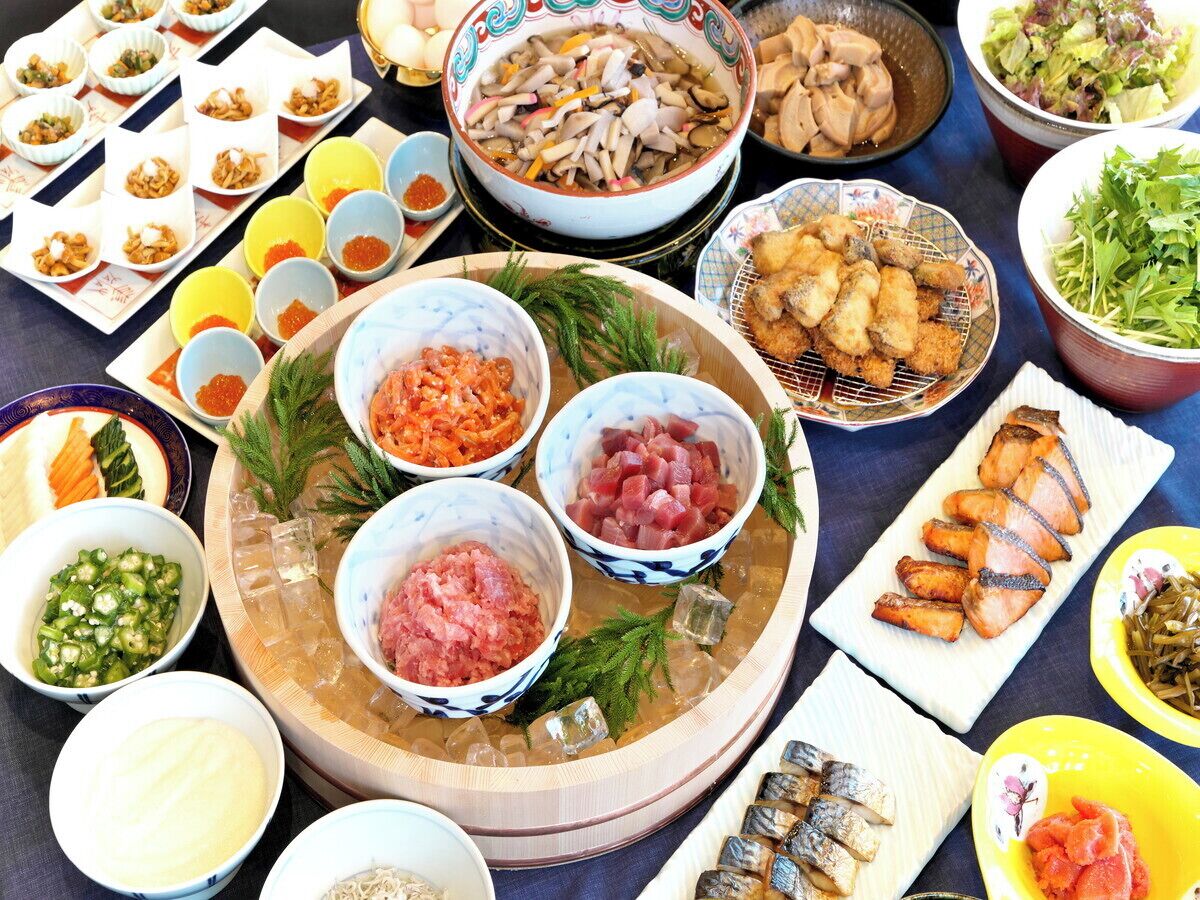 Diversos tipos de comida, entre ellos, cuencos de pescado crudo, verduras encurtidas y otros platos.
