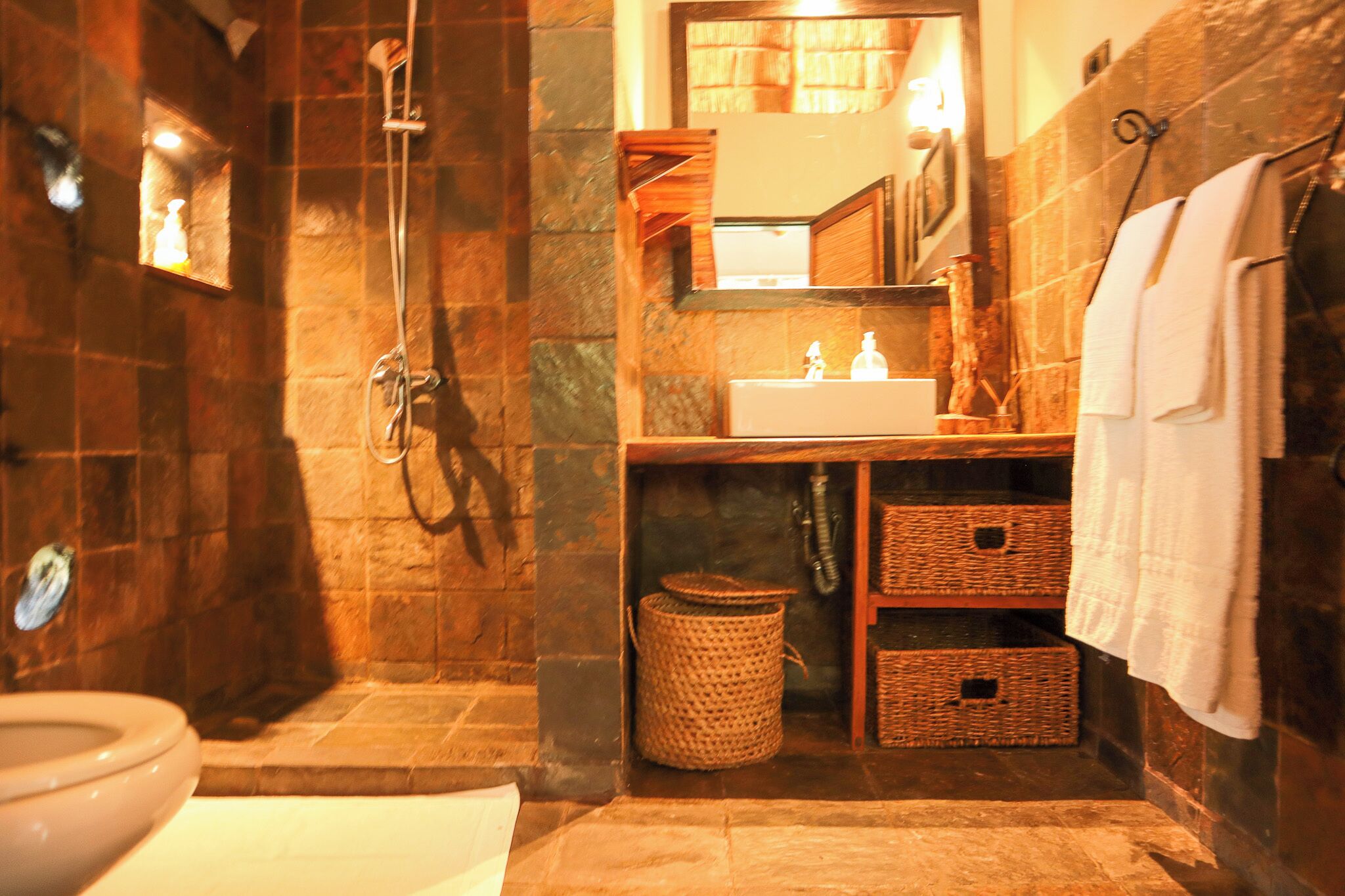 Une salle de bain équipée d’une douche, de toilettes, d’un lavabo et d’un miroir.