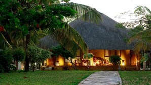 A thatched-roof building with a stone pathway leading to a porch. - Villas do Indico Eco - Resort & Spa Lodge (Vilanculos)
