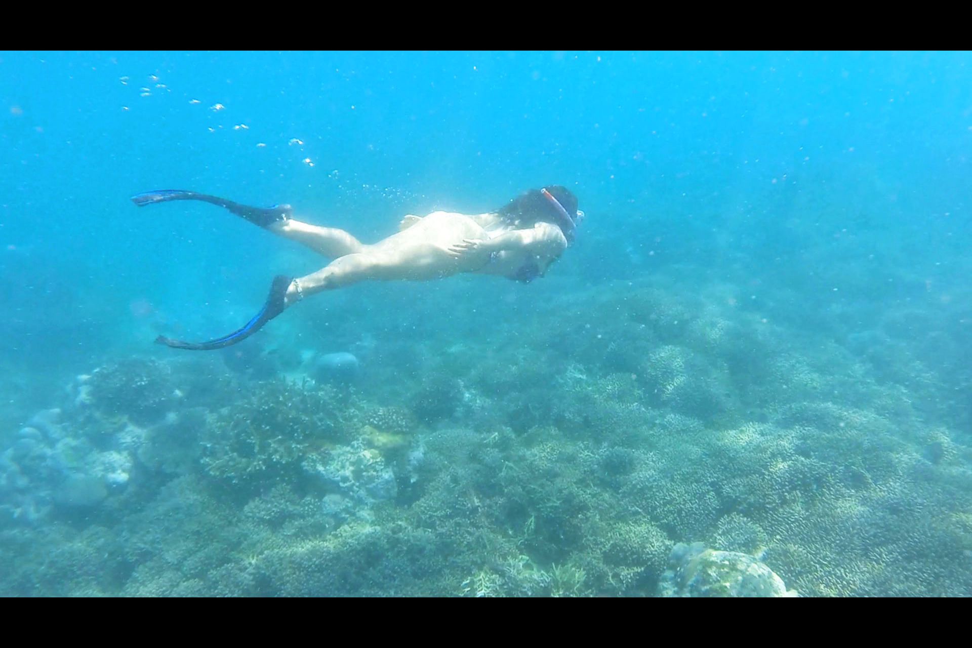 Eine Person beim Schnorcheln unter Wasser.