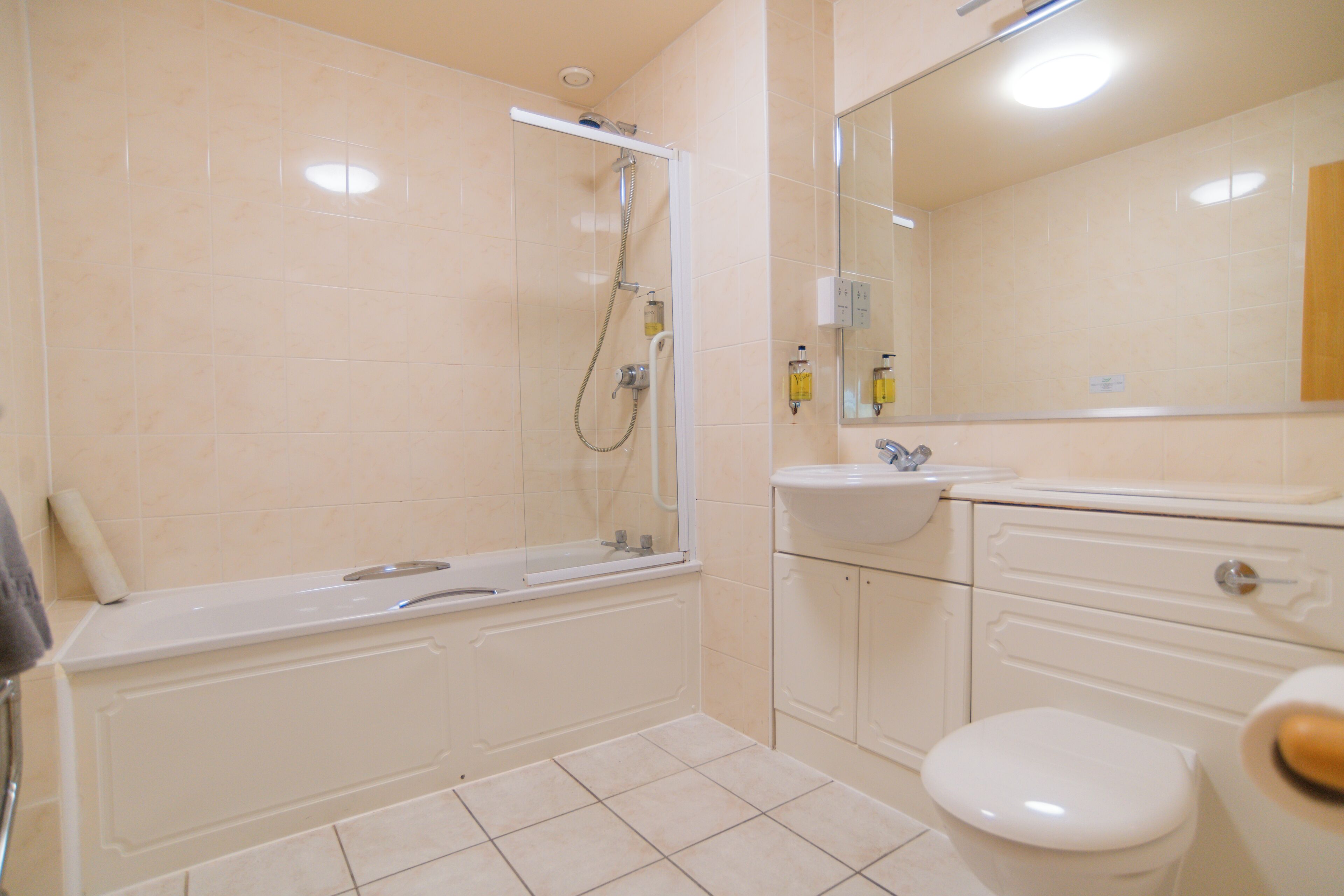 Ein Badezimmer mit einer Badewanne, einem Waschbecken, einer Toilette und einem Spiegel.