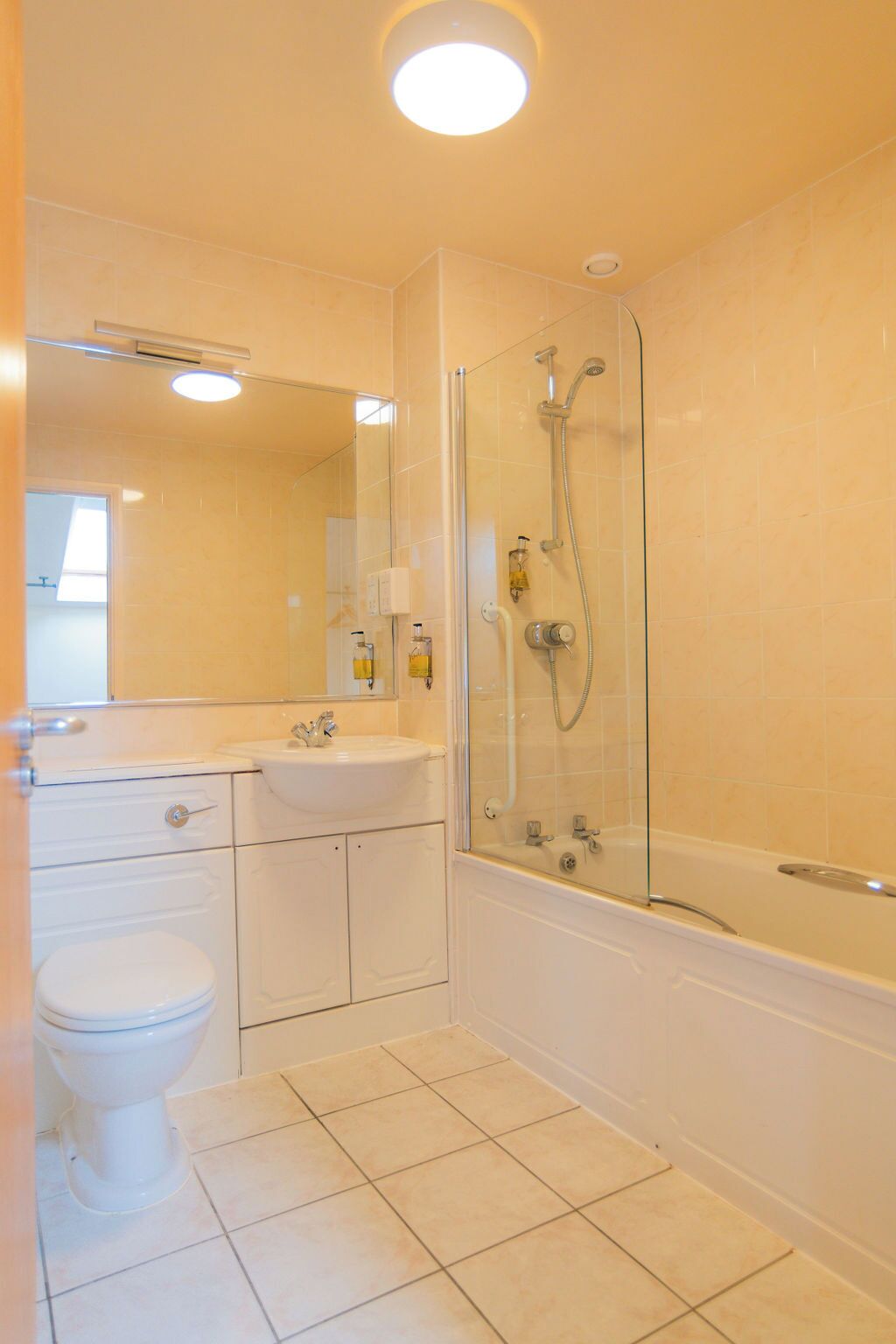 A bathroom with a toilet, sink, and glass-enclosed shower area.