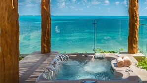A hot tub with a clear view of the ocean, surrounded by wooden pillars and glass railings. - Villa del Palmar Cancun Luxury Beach Resort & Spa (Punta Sam)