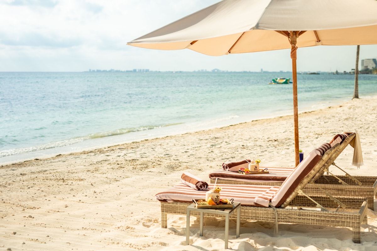 On the beach, white sand, sun loungers, beach umbrellas