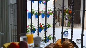 A breakfast table with fruits, a croissant, and a glass of orange juice. - Hotel Marisa (Córdoba)