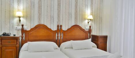 A double bed with a wooden headboard, two bedside tables, and a lamp on each side.