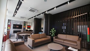 Un área de estar moderna con sofás, una mesa de centro y una pantalla de televisión.