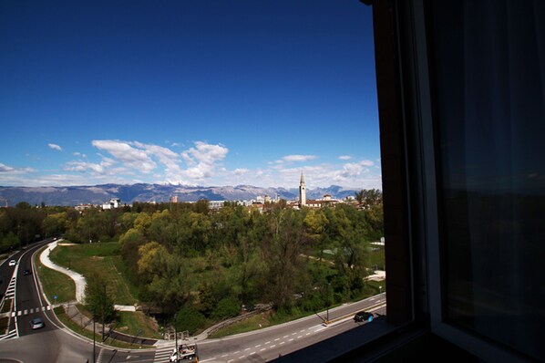 A view from a window overlooking a road with a mountain range in the background. - Hotel Santin (Pordenone)