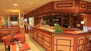 Un restaurant au décor en bois, avec un comptoir et une vitrine, et plusieurs espaces pour s’asseoir.