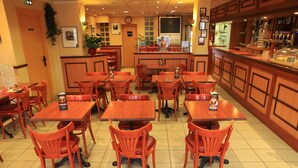 Un restaurant doté de nombreuses tables et chaises, d’un bar et d’un comptoir avec une vitrine.