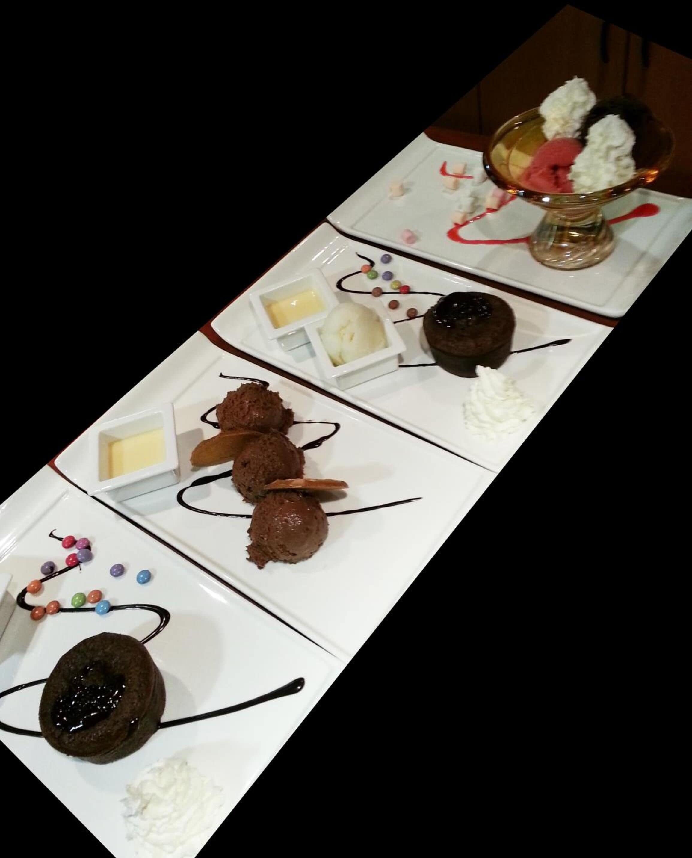Una mesa de postres con diversos dulces de chocolate y acompañamientos.