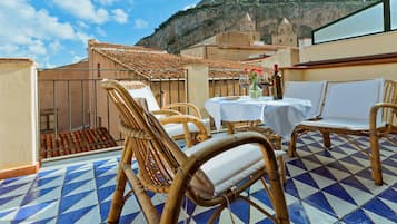 Relax on the terrace with wicker chairs and a table for two, taking in the breathtaking views of the surrounding mountains and historic buildings.