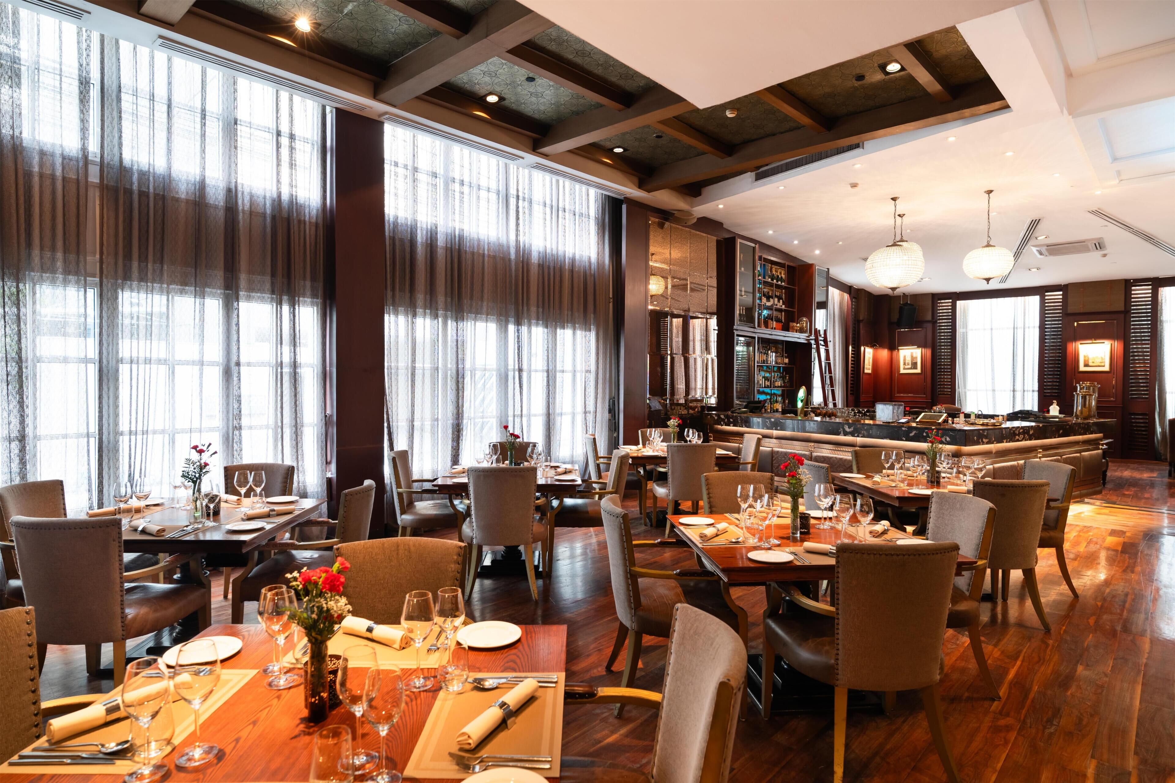 Ein Restaurant mit Holztischen, Stühlen und einer Bar.