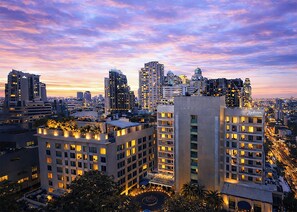 A high-rise building with multiple floors, a rooftop garden, and a sign for Radisson hotel. - Radisson Suites Bangkok Sukhumvit (Bangkok)