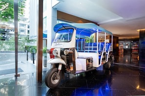 Ein Radisson Hotel mit modernem Interieur, einer Glasfassade und einem abgestellten Tuk-Tuk.