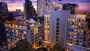 Un hotel de gran altura con varios pisos, un jardín en la azotea y un patio central.