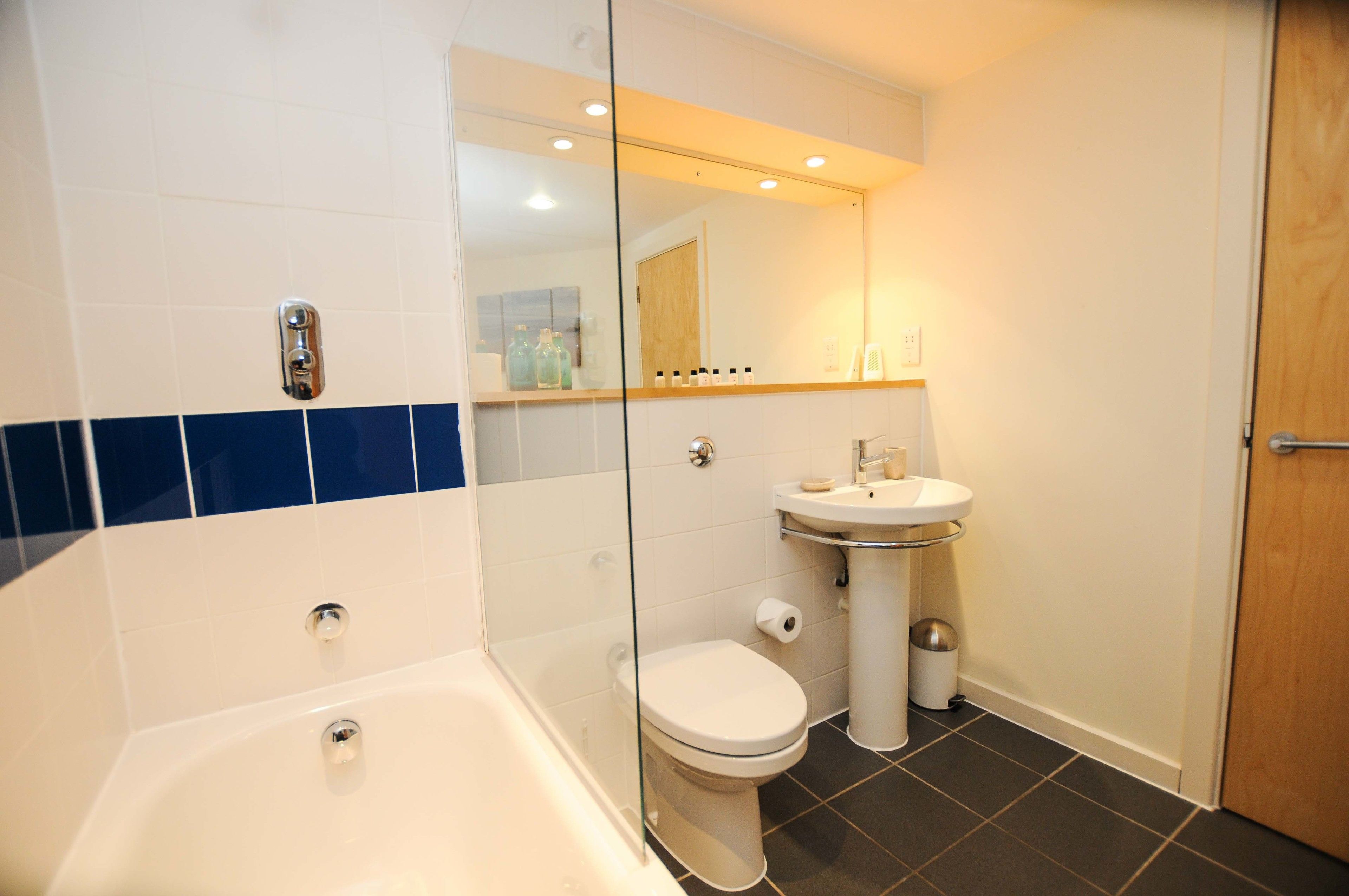 A modern bathroom with a bathtub, toilet, and sink.