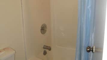 Un baño con bañera, inodoro y cortina de ducha.