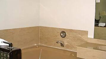 A bathroom with a bathtub, a mirror, and a toilet.