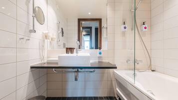 Une salle de bain moderne avec une douche à parois de verre, un lavabo blanc et des toilettes.