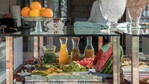 Un bufé con diversas opciones de comida y bebidas, incluyendo frutas, verduras y diferentes tipos de yogur.