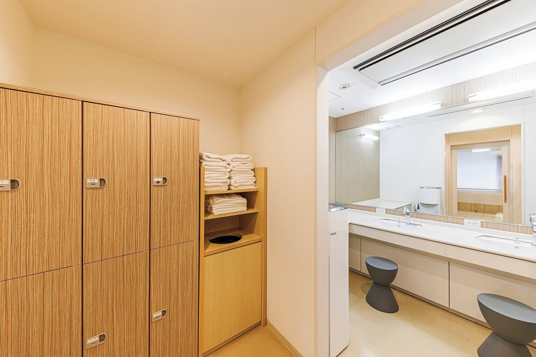 A modern bathroom with wooden cabinets, a sink, and a mirror.
