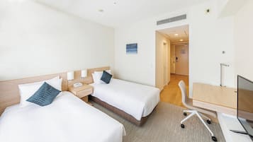 A hotel room with two beds, a desk, a chair, and a television.