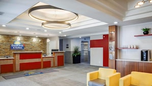 Un vestíbulo de hotel con recepción, zona de estar y estación de café.