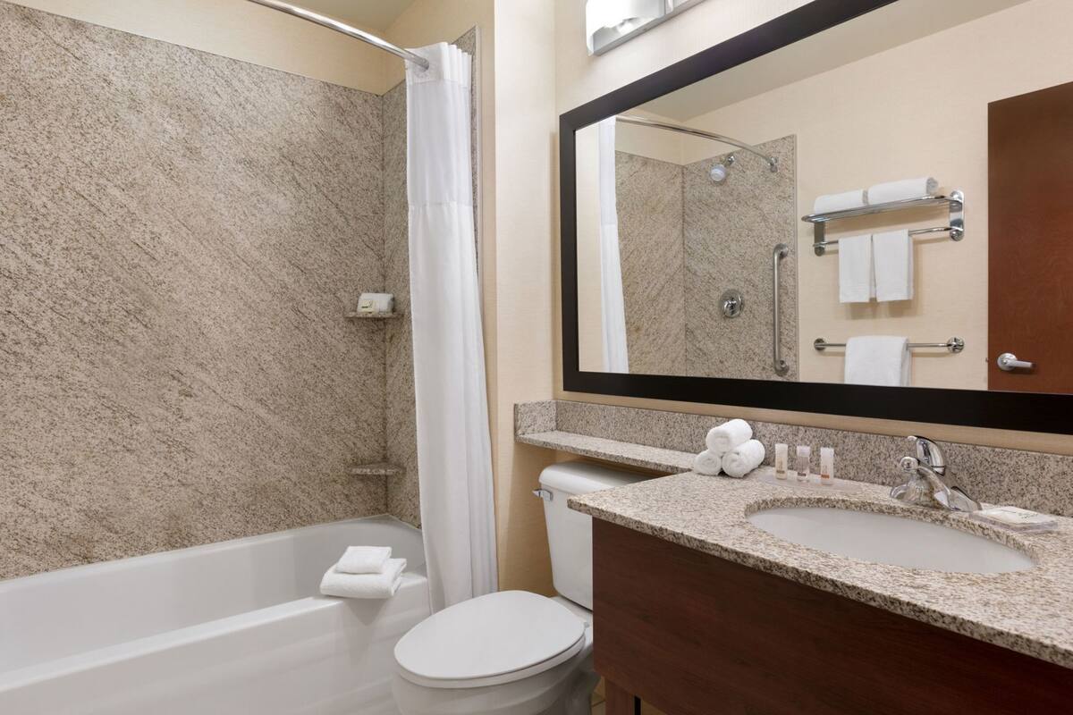 Un baño con bañera, inodoro y lavabo, todo en blanco.