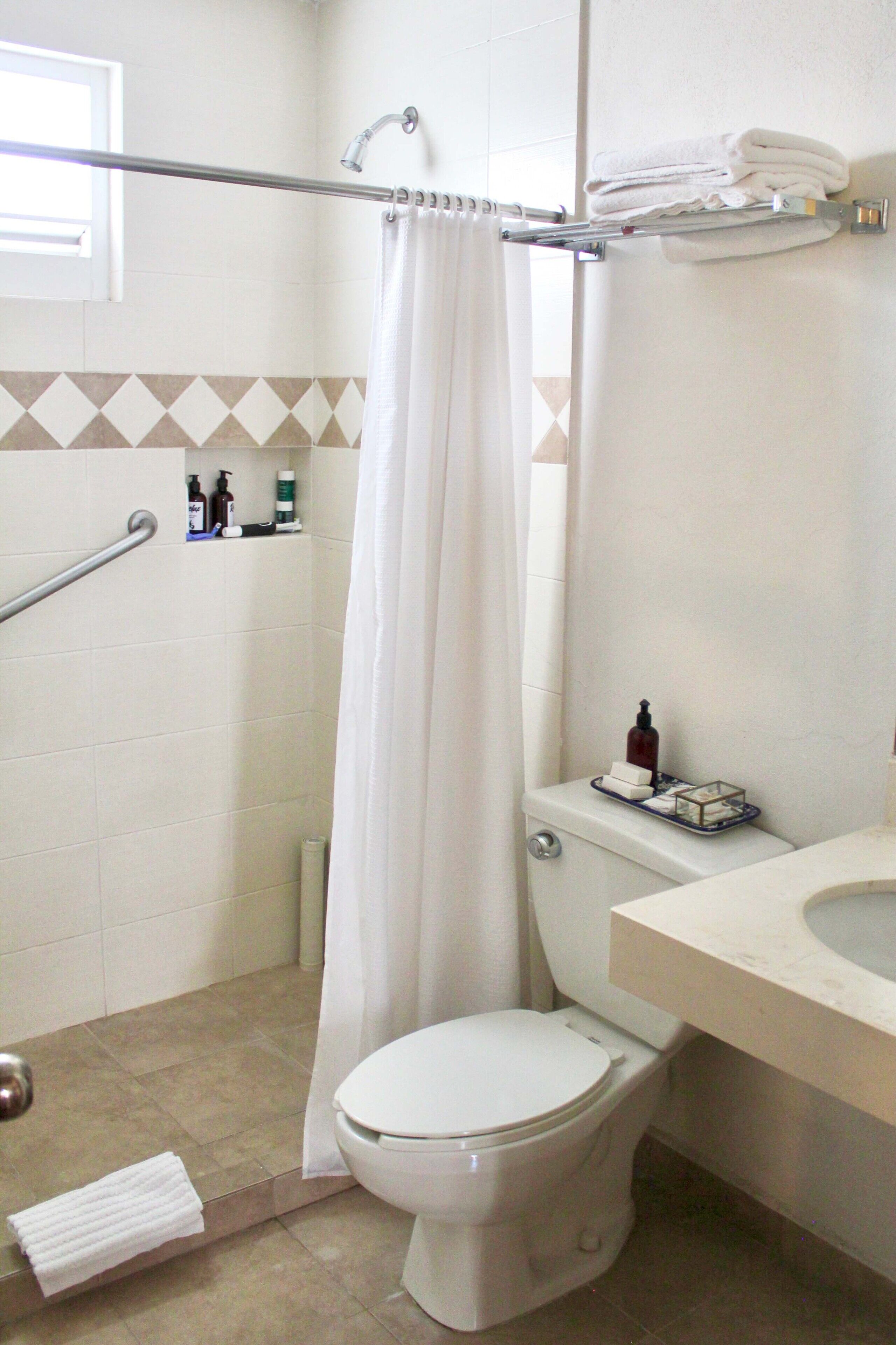 Ein Badezimmer mit Dusche, Toilette und Waschbecken.