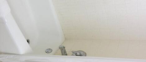 A bathroom with a bathtub, a toilet, and a sink.
