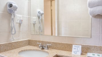 Een bad/douchecombinatie, een haardroger, handdoeken