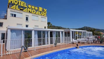 Una piscina al aire libre de temporada, sombrillas, tumbonas