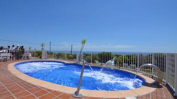 Een seizoensgebonden buitenzwembad, parasols voor strand/zwembad