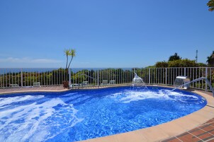Una piscina al aire libre de temporada, sombrillas