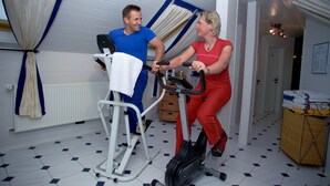 A room with a stationary bike, a white radiator, a wicker basket, and a tiled floor. - Hotel Höhn (Ruedesheim am Rhein)