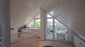 A spacious kitchen with white cabinetry and a large window overlooking a balcony. - Gästehaus Alba (Rust)