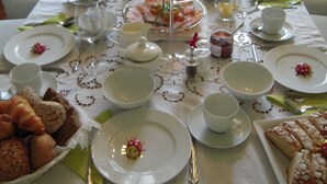 A long dining table set with plates, glasses, and various food items, suggesting a formal meal setting. - mittendrin - Boutique Hotel Berlin (Berlin)