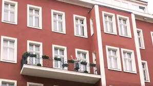 A red building with white-framed windows and a balcony with railings and potted plants. - mittendrin - Boutique Hotel Berlin (Berlin)