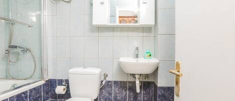 Een badkamer met toilet, wastafel en douche.
