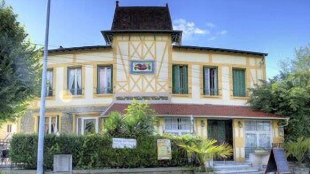 A two-story building with a yellow facade, a red roof, and a small balcony. - Auberge des Ecluses (Carrieres-sous-Poissy)