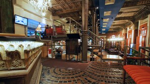 A spacious lobby with a high ceiling, a central staircase, and a patterned floor. - La Fresque Hotel (Buenos Aires)