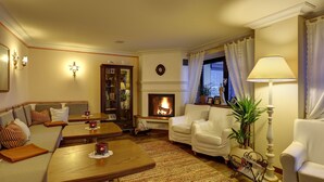 Una sala de estar acogedora con chimenea, un sofá, una mesa de centro y una lámpara.