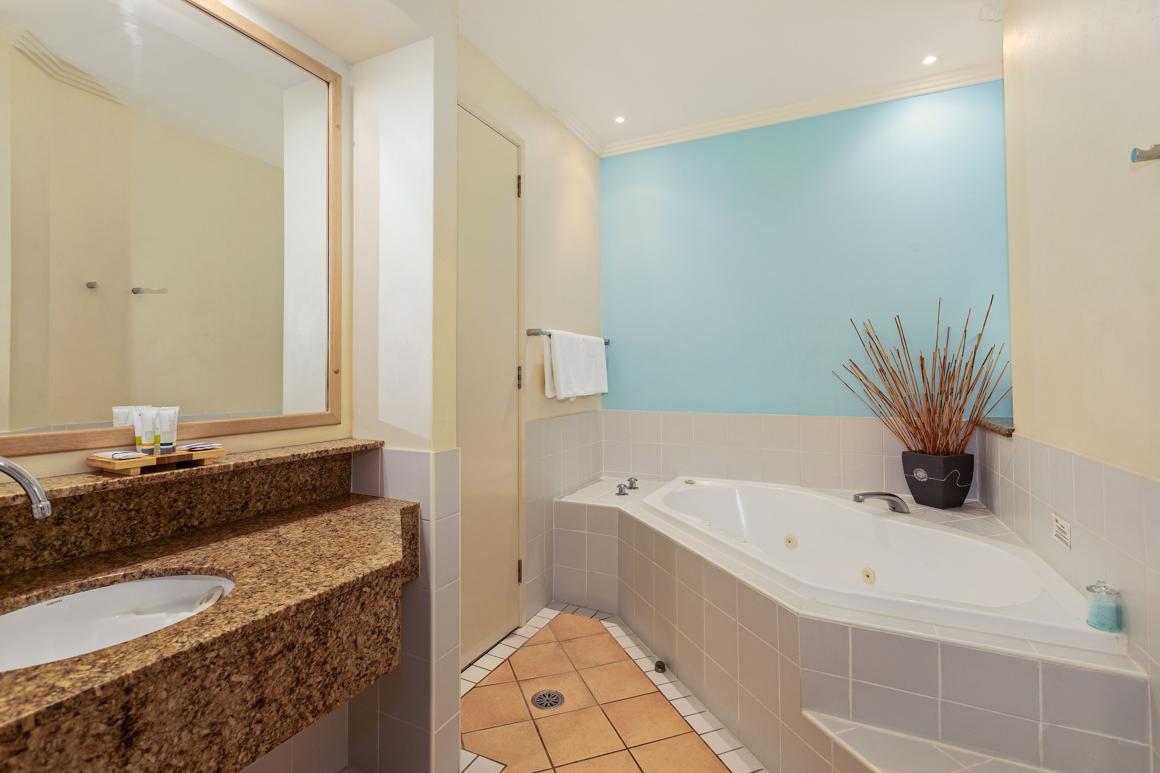 Un baño con lavamanos, espejo y bañera.