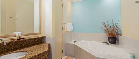 Un baño con lavamanos, espejo y bañera.