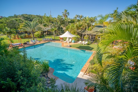 Una piscina al aire libre, camas de piscina gratis, sombrillas