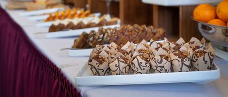 A buffet table with various food items and a decorative centerpiece.