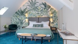 A bedroom with a bed, a nightstand, a chair, a table, and a wall mural. - Domaine et Golf de Vaugouard - La Maison Younan (Fontenay-sur-Loing)