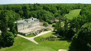 A large, historic building with multiple wings, surrounded by well-maintained lawns and a golf course. - Domaine et Golf de Vaugouard - La Maison Younan (Fontenay-sur-Loing)